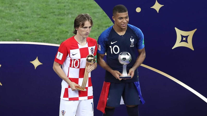 Luka Modric and Kylian Mbappe pose with individual awards