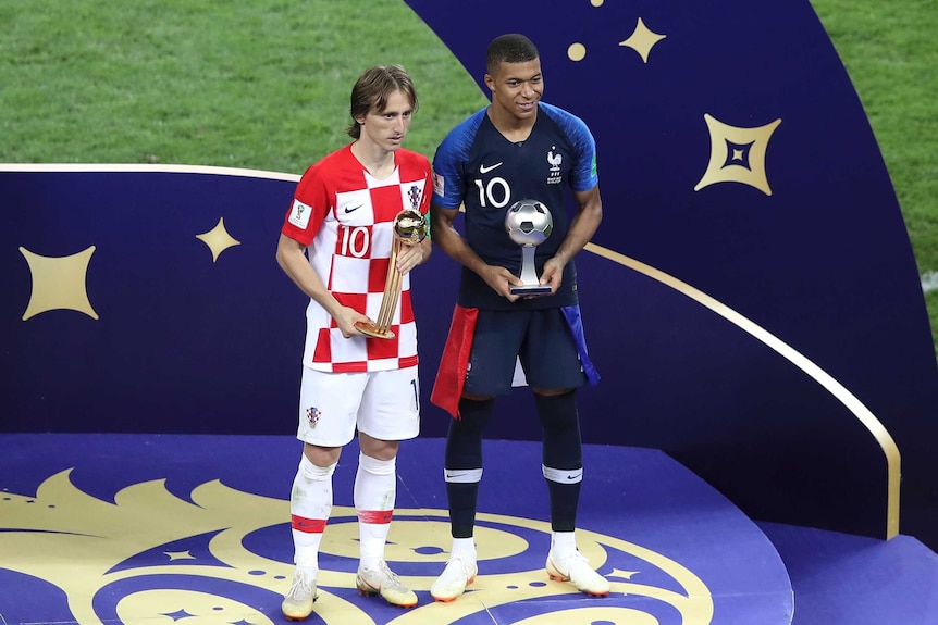 Luka Modric and Kylian Mbappe pose with individual awards