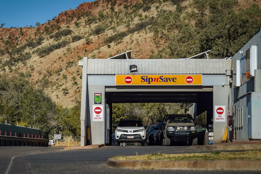 Cars line up at a drive through liquor store.