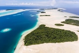 Island of white sands surrounded by blue sea.