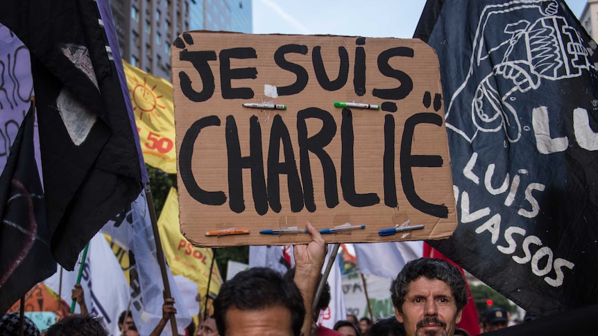 A demonstrator holds a Je Suis Charlie placard at a protest.