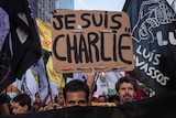 A demonstrator holds a Je Suis Charlie placard at a protest.