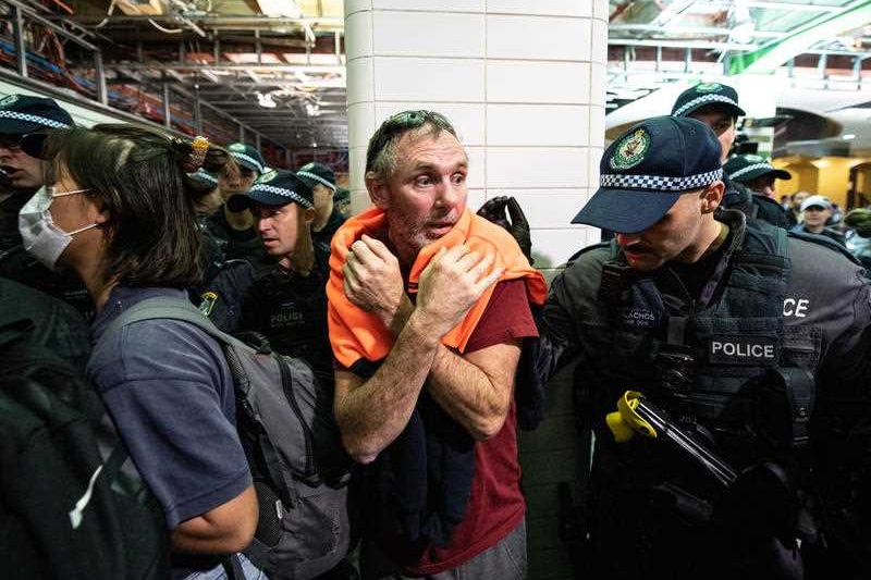 A crowded train station with police and passengers.