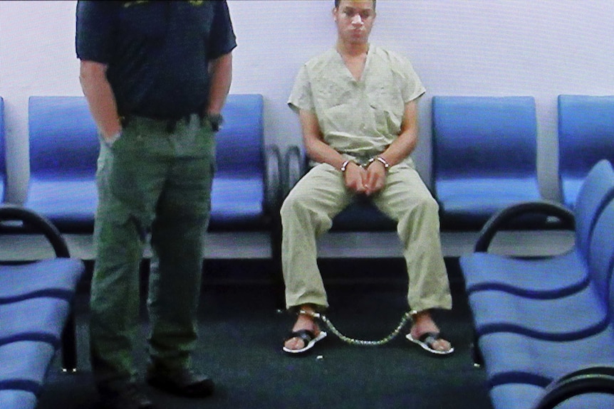 A young man in handcuffs