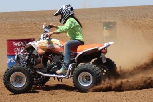 Girl on a quad in the middle of the desert