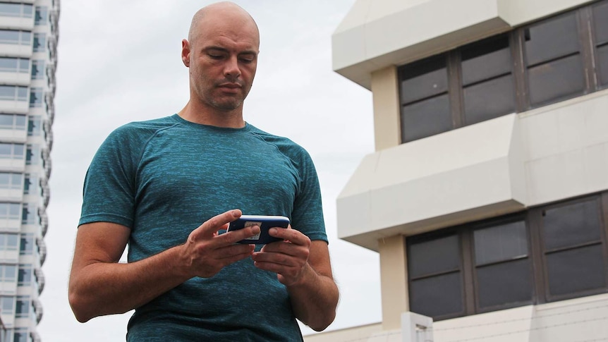 A photo of thermal heat expert Matt Brearley holding a handheld receiver.