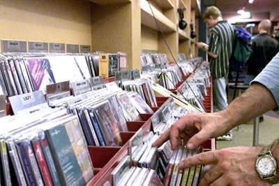 Customers in a music store look through compact discs