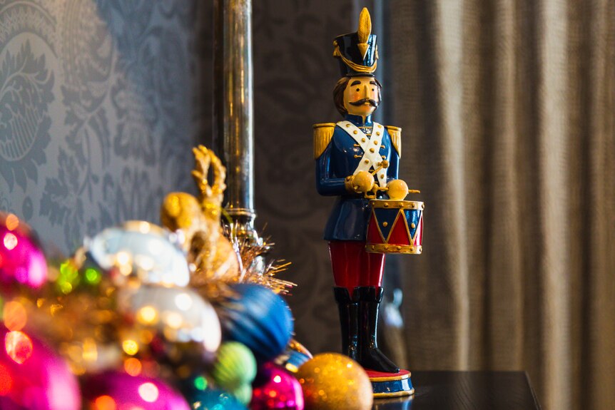 A nutcracker king Christmas decoration sits on a table. 