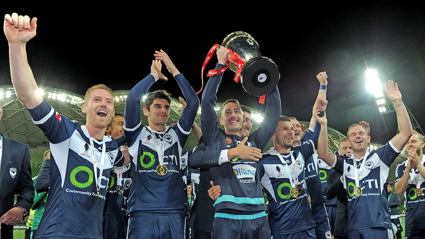 Melbourne Victory players celebrate with the FFA Cup