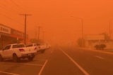 Cars are parked in the main street of Mildura's CBD as an orange haze totally fills the sky, lowering visibility significantly.