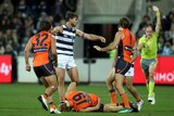 Nick Haynes from GWS lies on the ground after being knocked down by Tom Hawkins of Geelong during a marking contest.