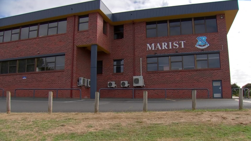 A red brick school building with the word 'Marist' visible.