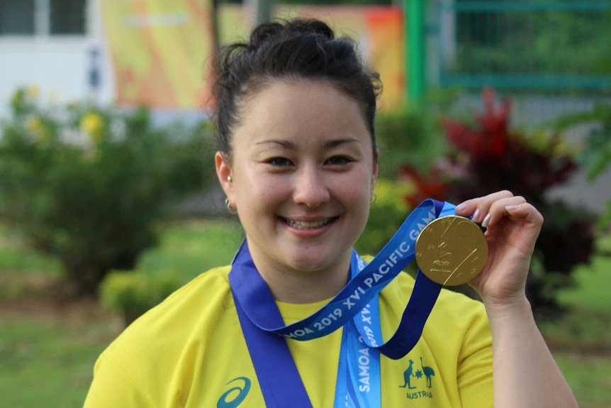 Erika Yamasaki wears her three gold medals at the Pacific Games.
