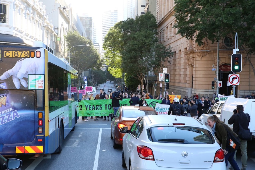 A couple dozen of protesters stand in the middle of the street in Brisbane's city.