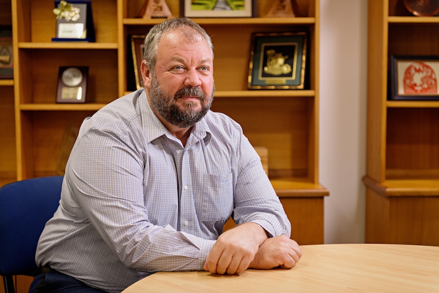 A man sits at his desk. 