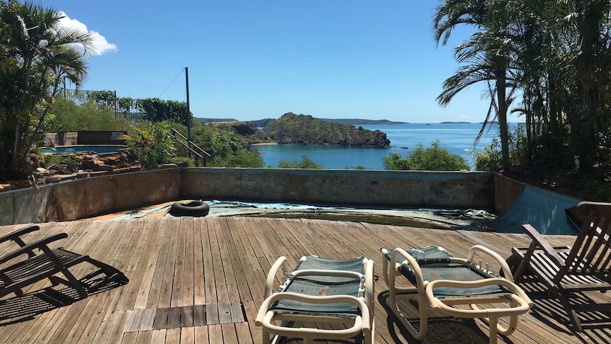 Old chairs on a deck looking out to the sea from a chalet at the old Cockatoo Island Resort