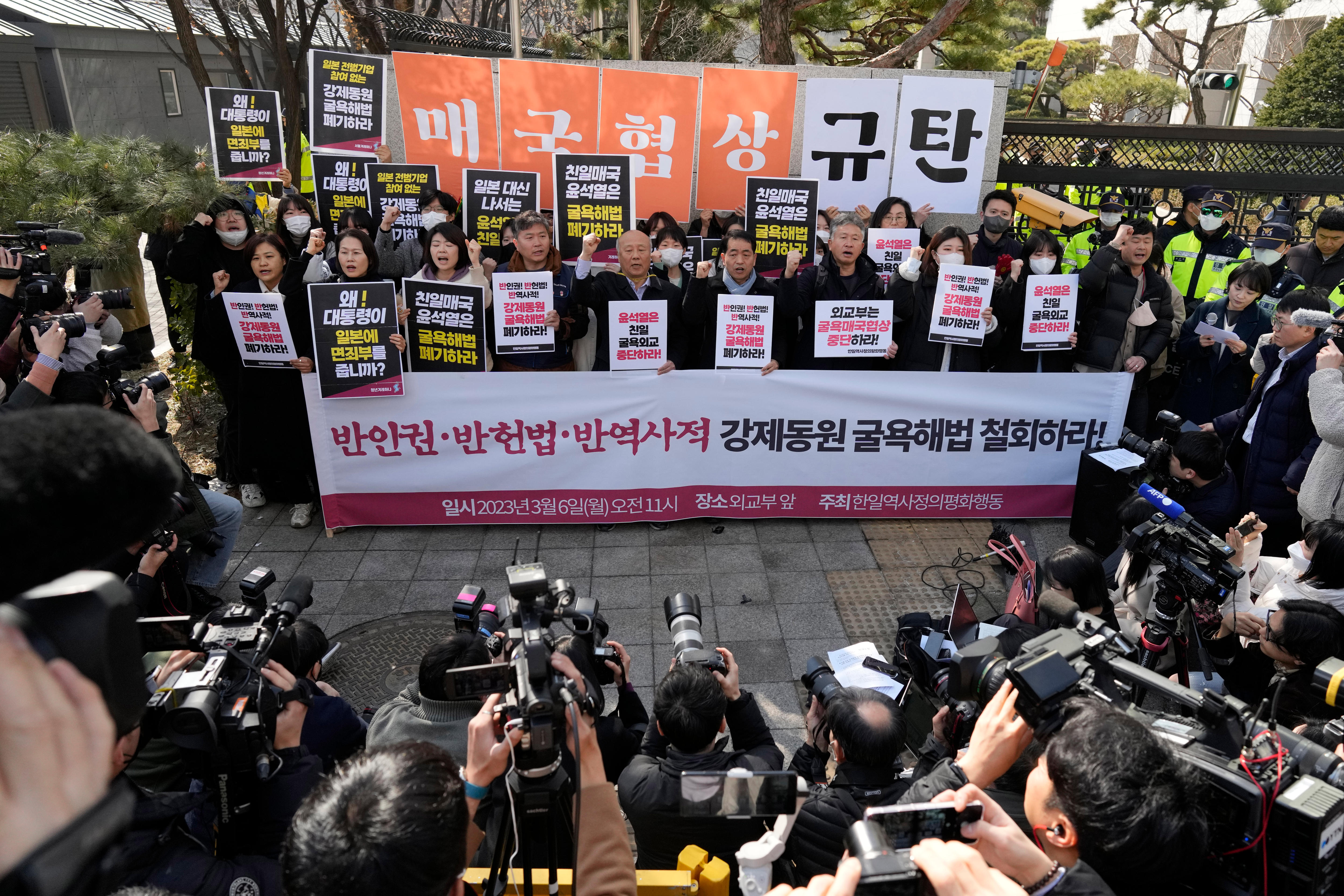 People hold signs and chant during a protest.