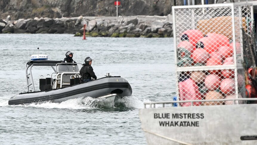 Two men in tactical gear on board a boat