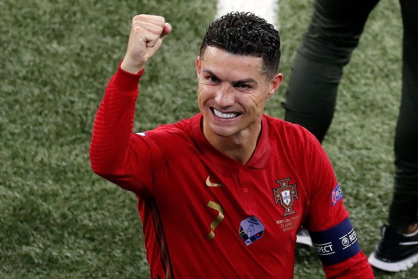 Ronaldo holds his fist up and smiles