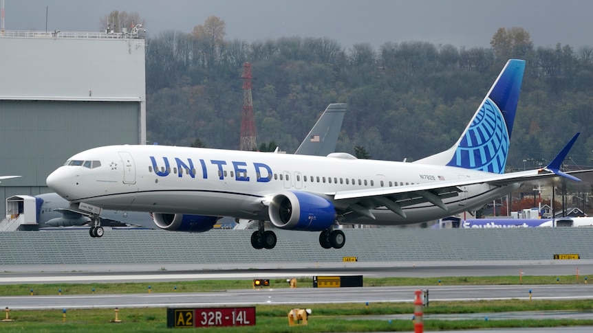 A wide shot of a Boeing 737 Max 9 airliner with United Airlines branding landing at an airport