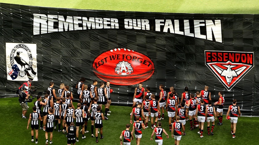 Pies, Bombers players run through Anzac banner