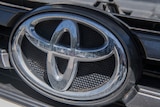 A metalic Toyota symbol on a White Toyota Hi-Lux with the defective DPF.
