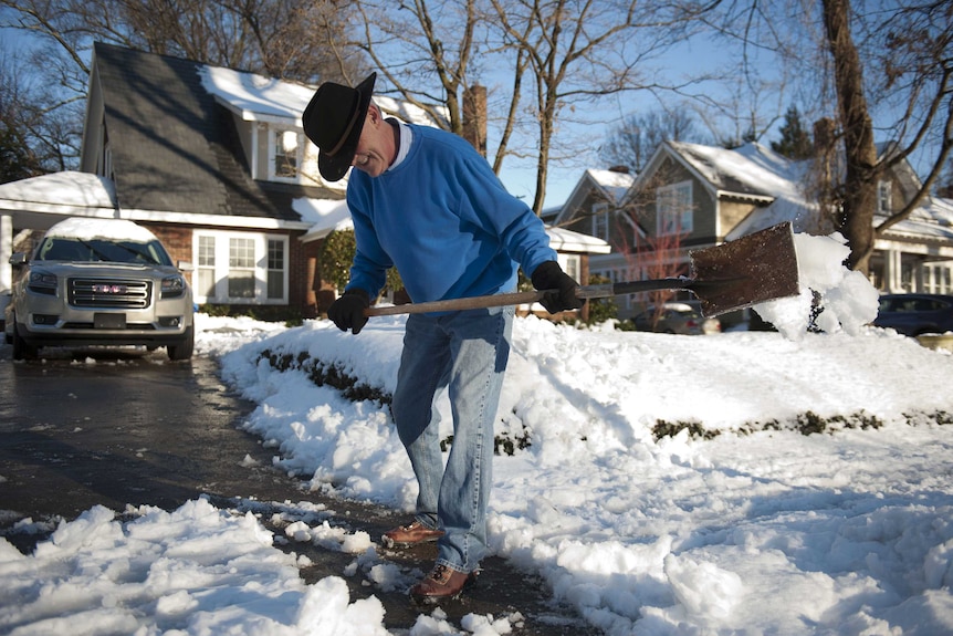 Man clears snow-covered driveway in North Carolina