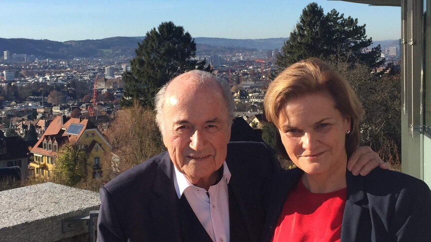 Sepp Blatter and Bonita Mersiades pose on a balcony overlooking a valley in the background