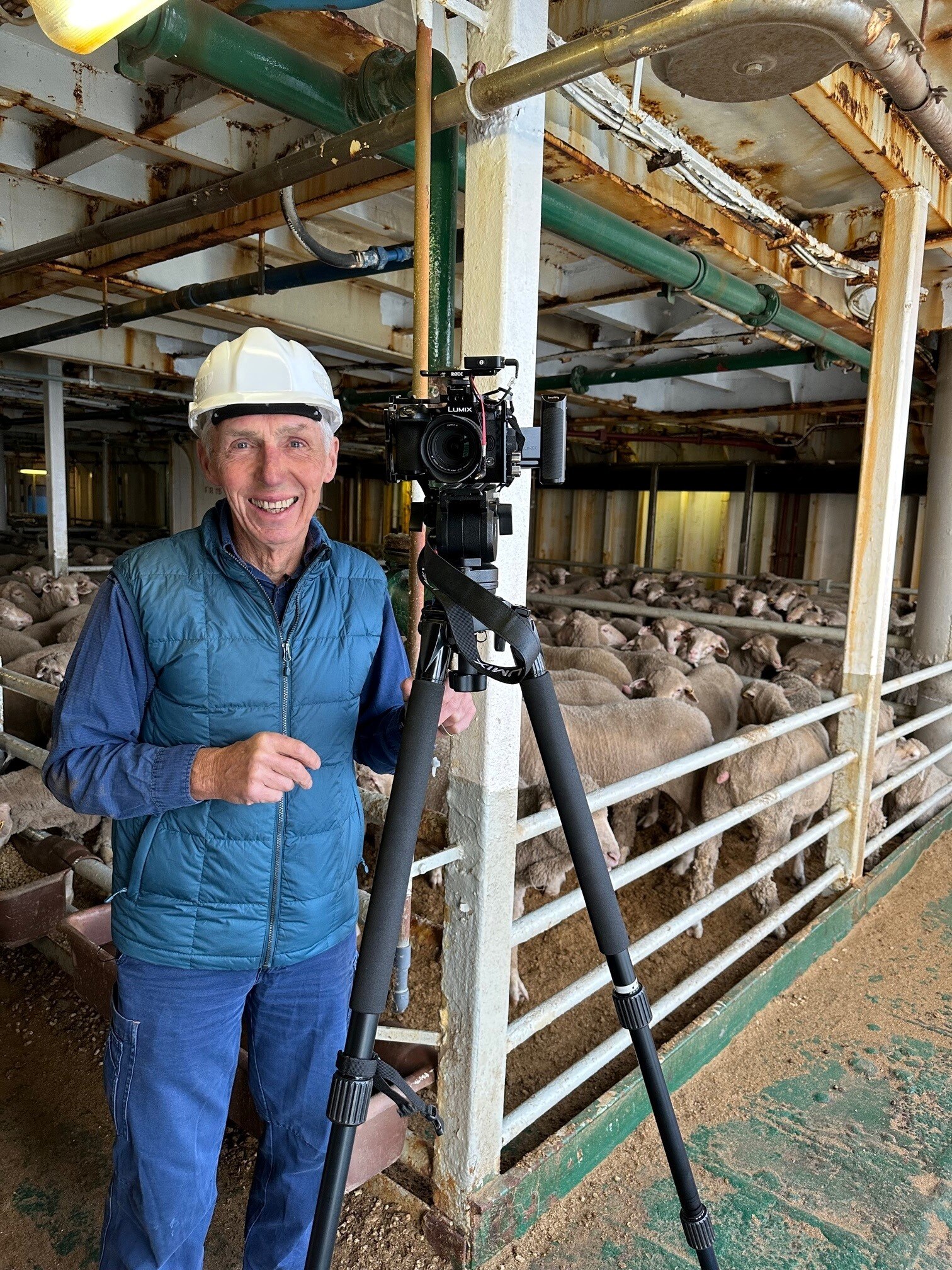 Reporter in hard hat on board ship.