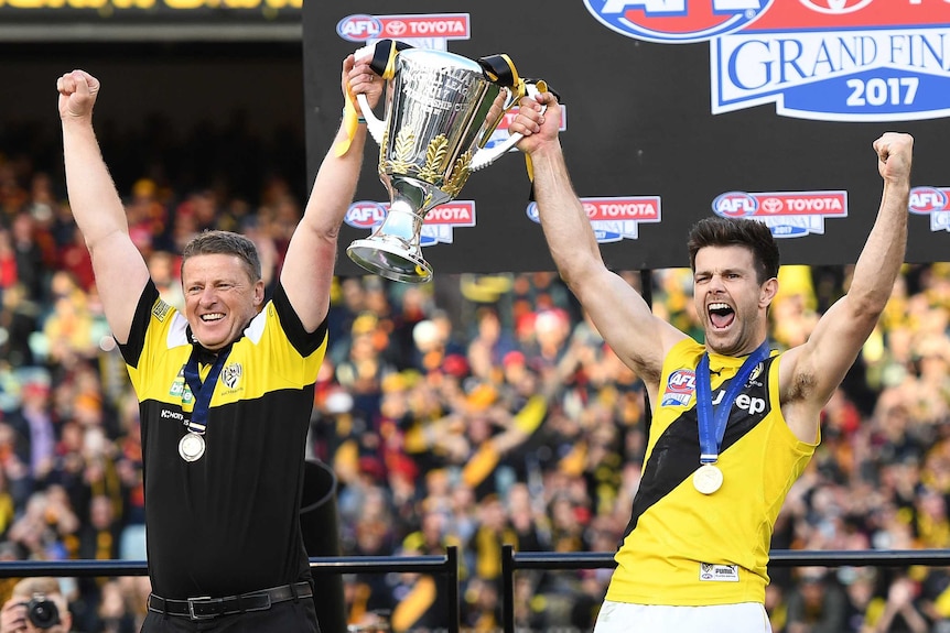 Richmond's Damien Hardwick and Trent Cotchin cheer as they raise the premiership cup.