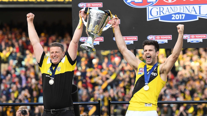 Damien Hardwick and Trent Cotchin cheer as they raise the premiership cup.