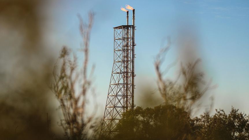 Flare towers with fire coming out of the top.