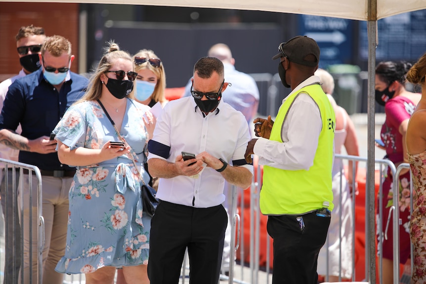 People line up for security checks outside an outdoor event