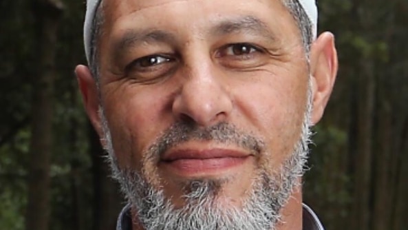 Close up portrait of smiling man, approx in his forties, with white cap and grey-flecked beard