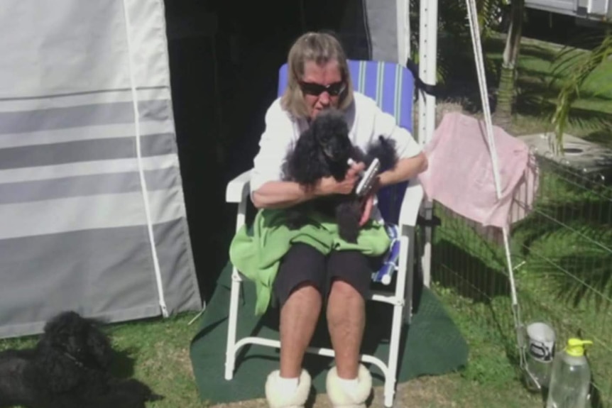 A woman sitting outside a caravan.