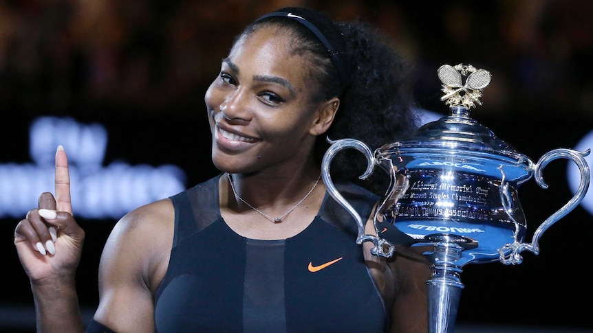 Serena Williams raises a finger and the trophy after winning the Australian Open title in 2017.