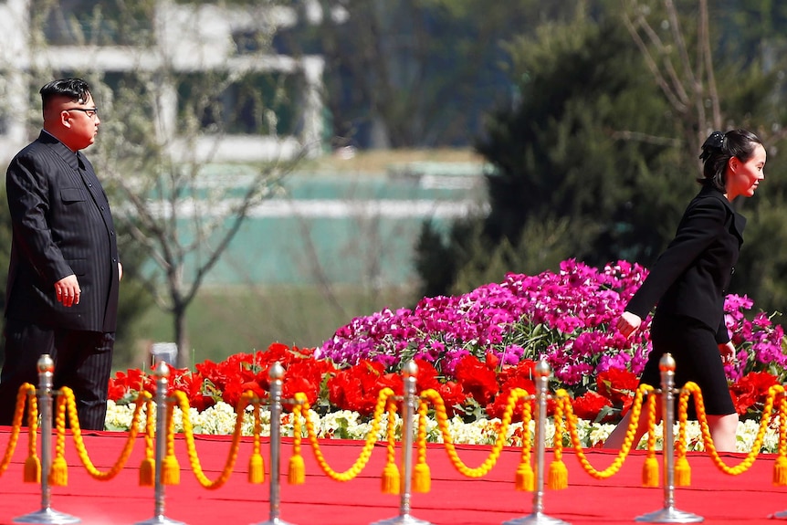 Kim Yo-jong walks ahead of  her brother Kim Jong-un down a red carpet.