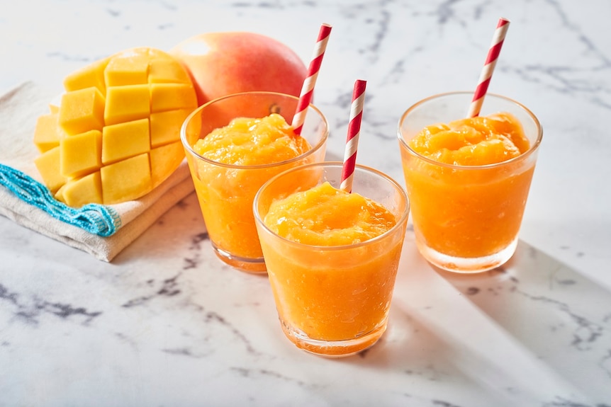 Mango granitas next to a cut up mango