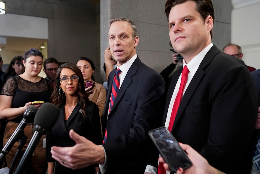 Republican members of Congress Scott Perry, Lauren Boebert and Matt Gaetz gather around microphones surrounded by press