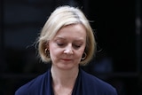 Liz Truss looks down as she delivers a speech in front of the black door of No 10.