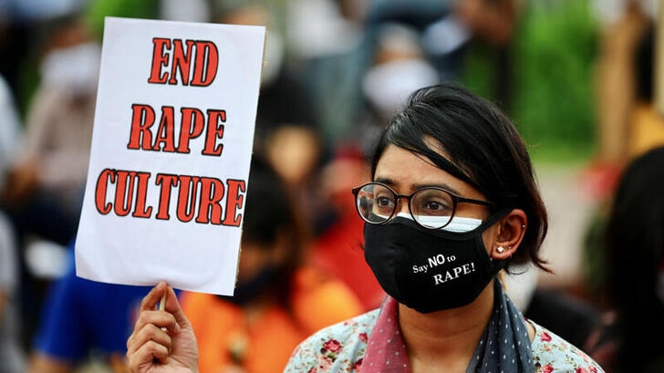 A woman with a protest sign saying: 'End rape culture' during protests in Bangladesh.