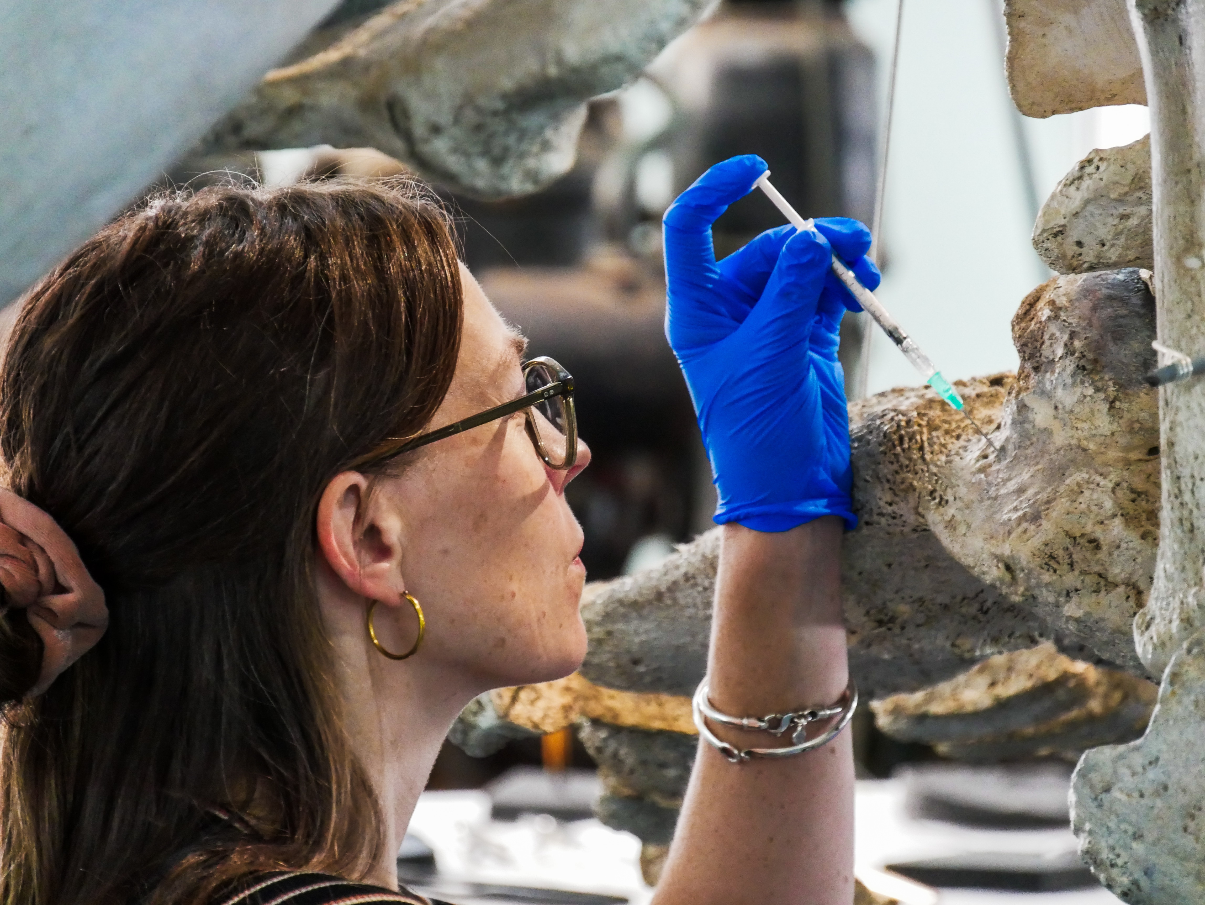 A woman sticks a syringe into a bone