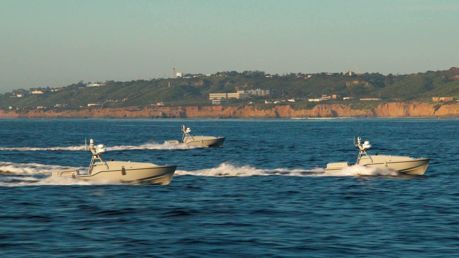 Three sea drones that look like jet skis operating autonomously in the water.