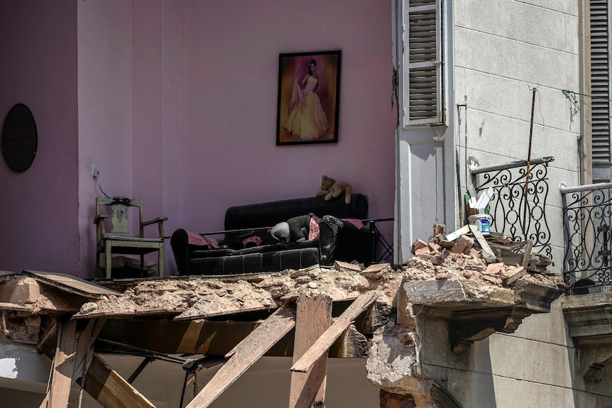 A portrait adorns a wall in the living room of a home destroyed by a deadly explosion