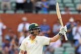 Australia batsman Travis Head points his bat skyward as the Adelaide Oval crowd watches on.
