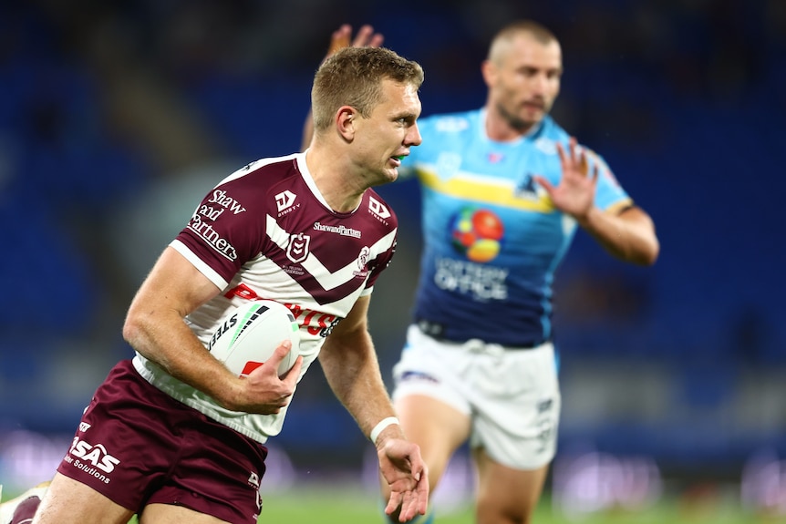 One rugby league player running down field, with an opponent in the distance