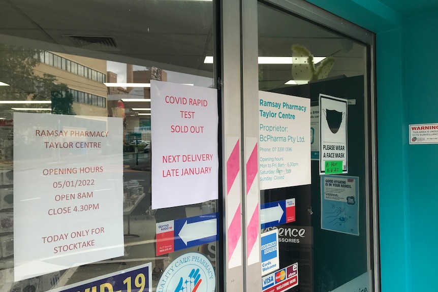Sign on front door of Brisbane pharmacy advising people 'COVID rapid test sold out, Next delivery late January'