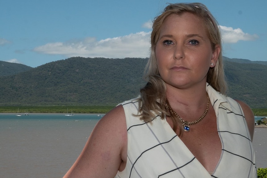 Virginia Giuffre stands on a balcony with Cairns harbour behind her.