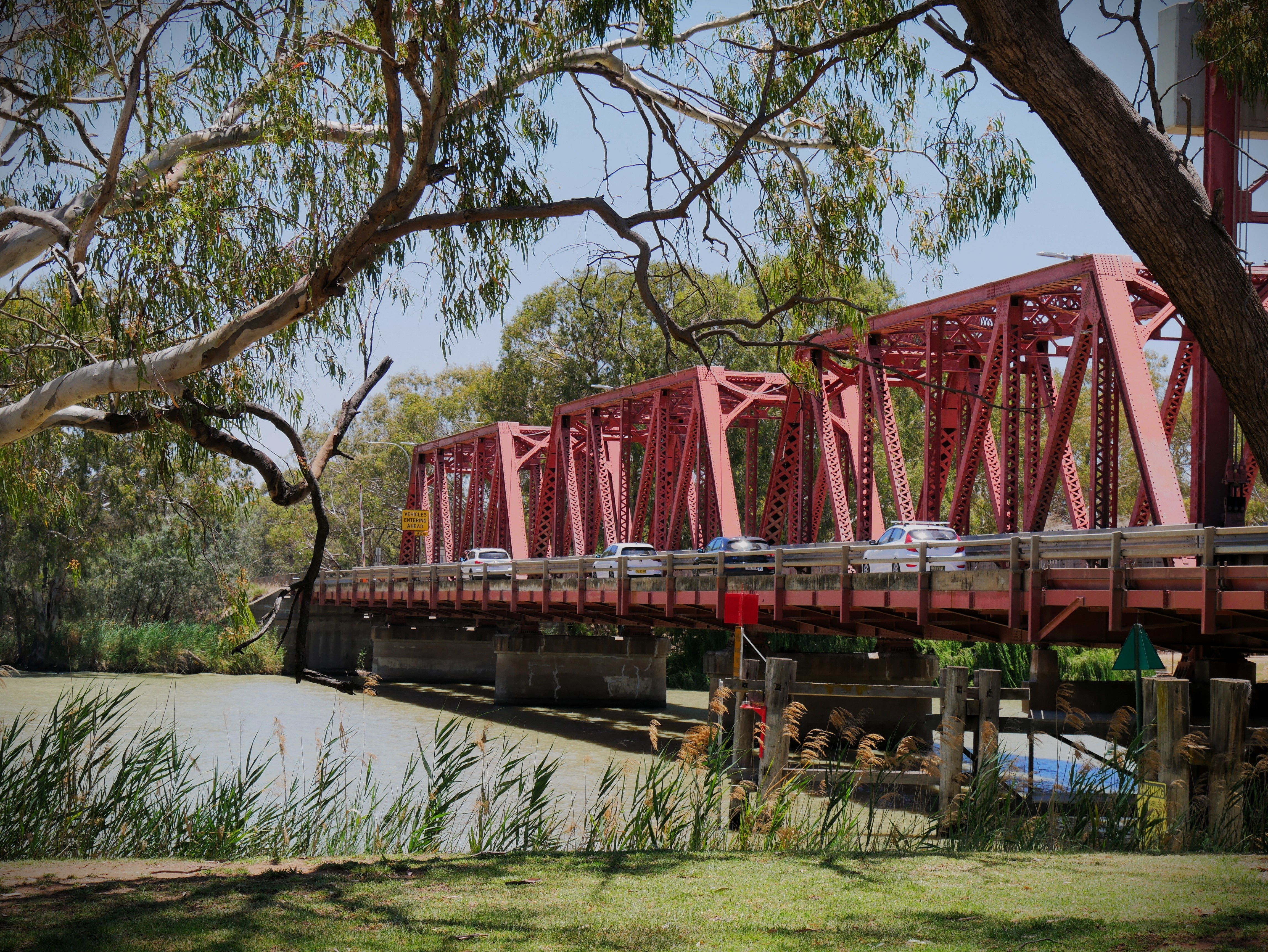 Carros dirigindo na ponte vermelha. 