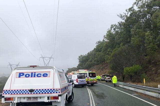 Police an emergency services at attend to two cars on a misty road.